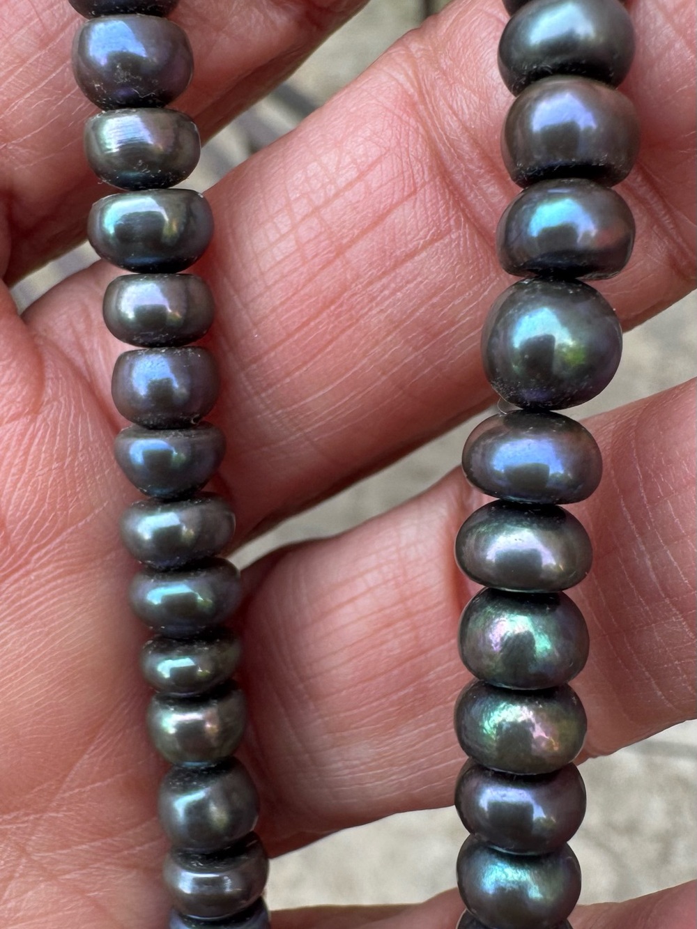 Beautiful cultured peacock color button pearls. Sterling silver clasp.